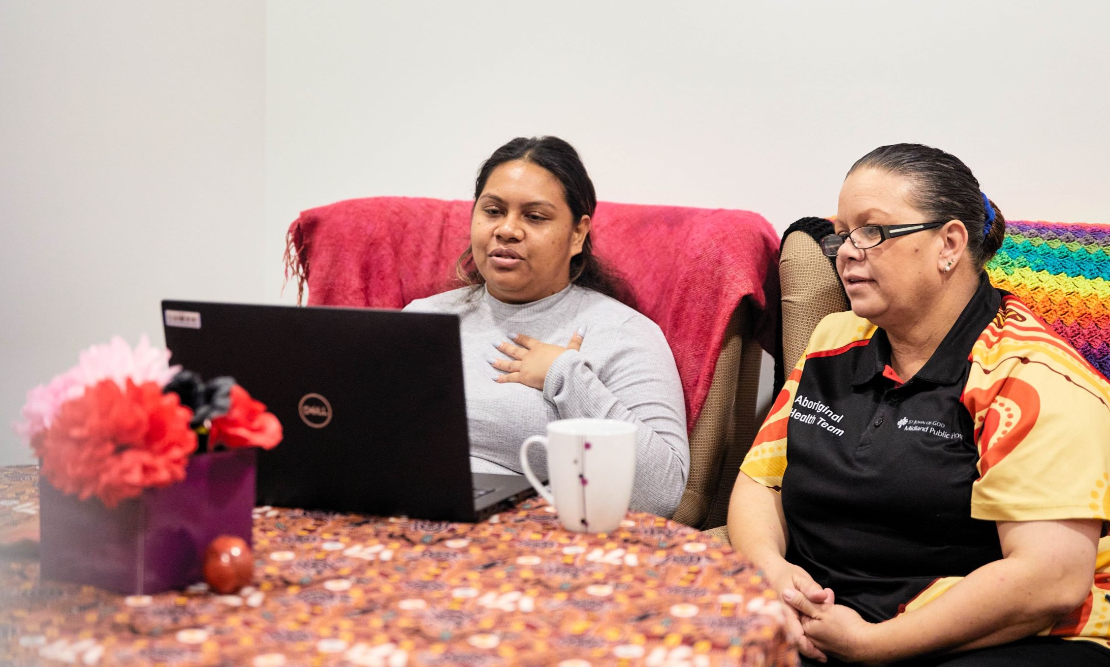 Two patients sitting on couch at home looking at tablet.jpg